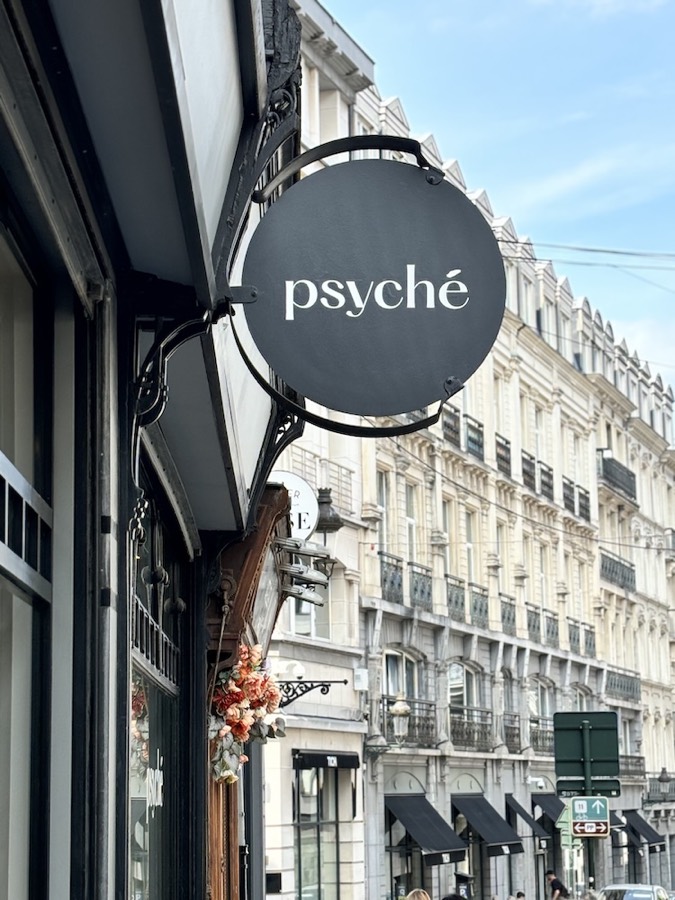 Firmă rotundă cu inscripția „psyché” pe o stradă cu clădiri vechi